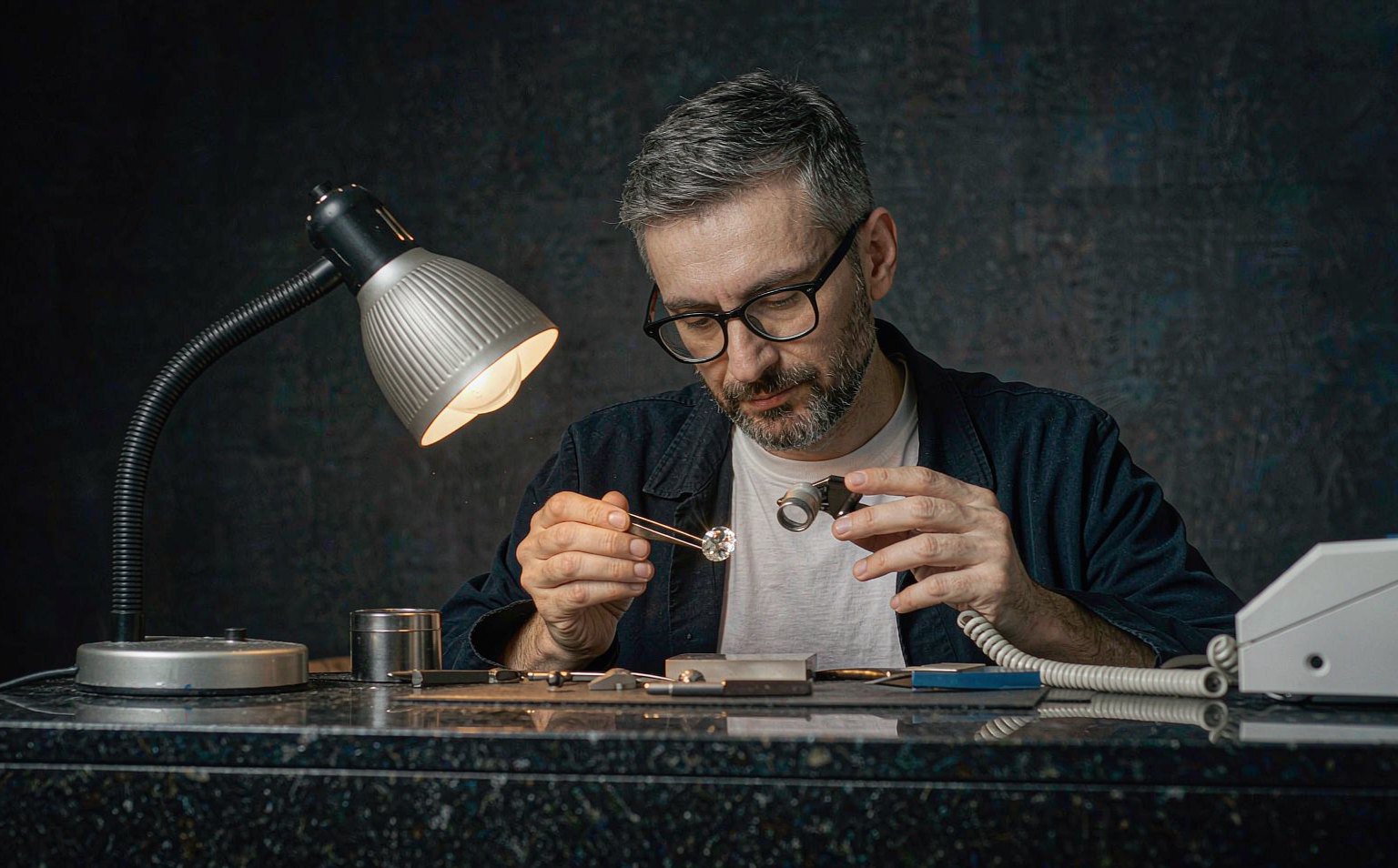 Gemologist examining a moissanite with a loupe magnifier